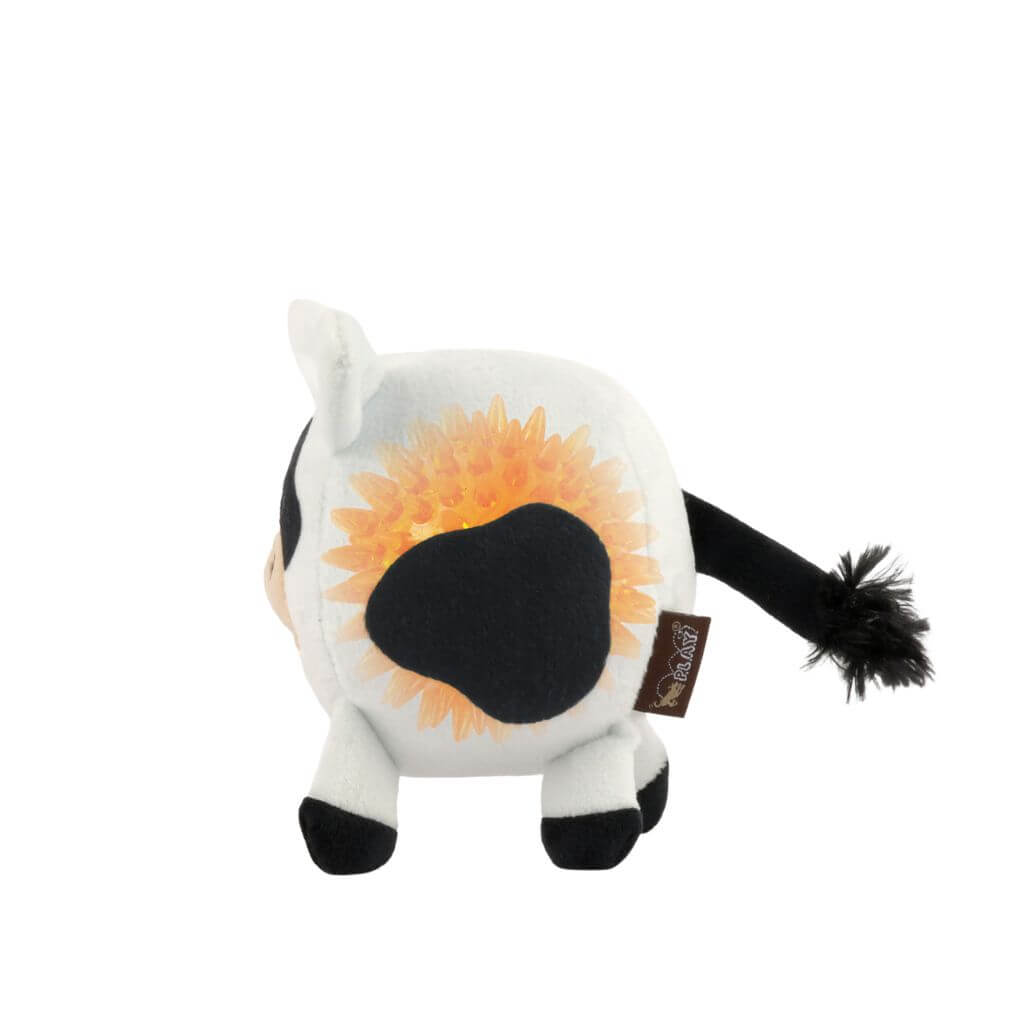 Underside of the PLAY Barnyard Buddies, Cole the Cow dog toy that showcases a spiky rubber ball on the bottom against a white background.