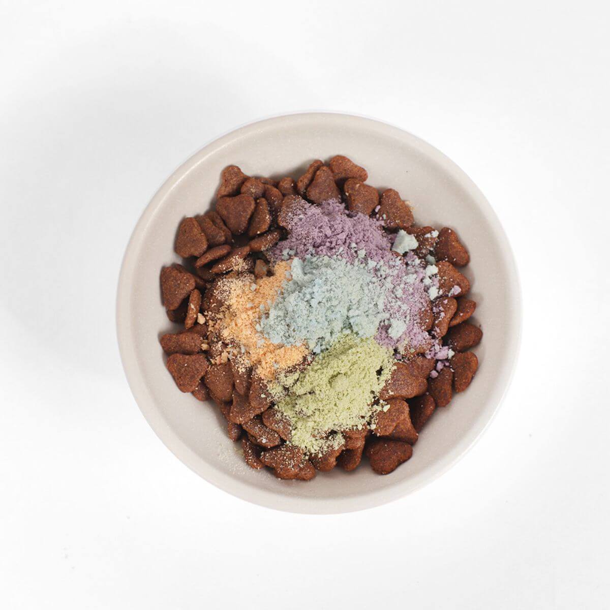 Arlo Kitchen Goat Milk Calming treats grinded into powder and sprinkled over food in a bowl.