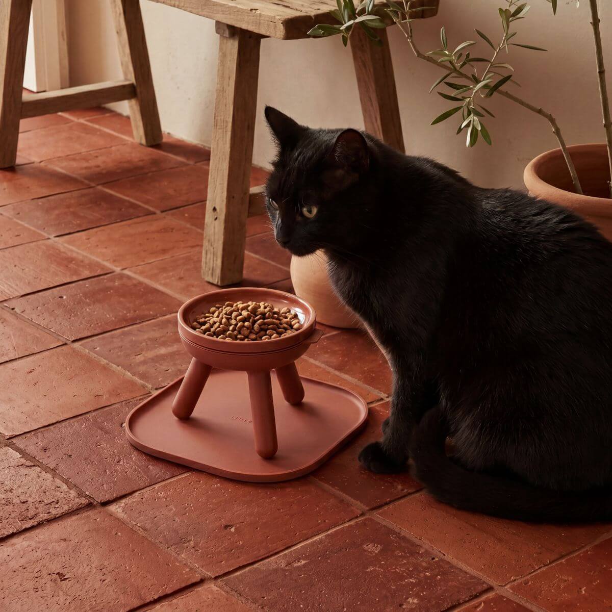inherent outdoor oreo table brick against a living room setting with a black cat.