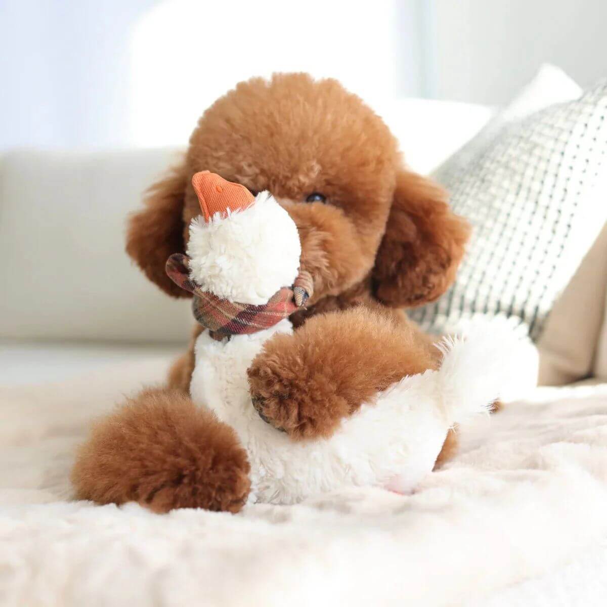 A brown poodle mix cuddling the Lambwolf Gus Goose.