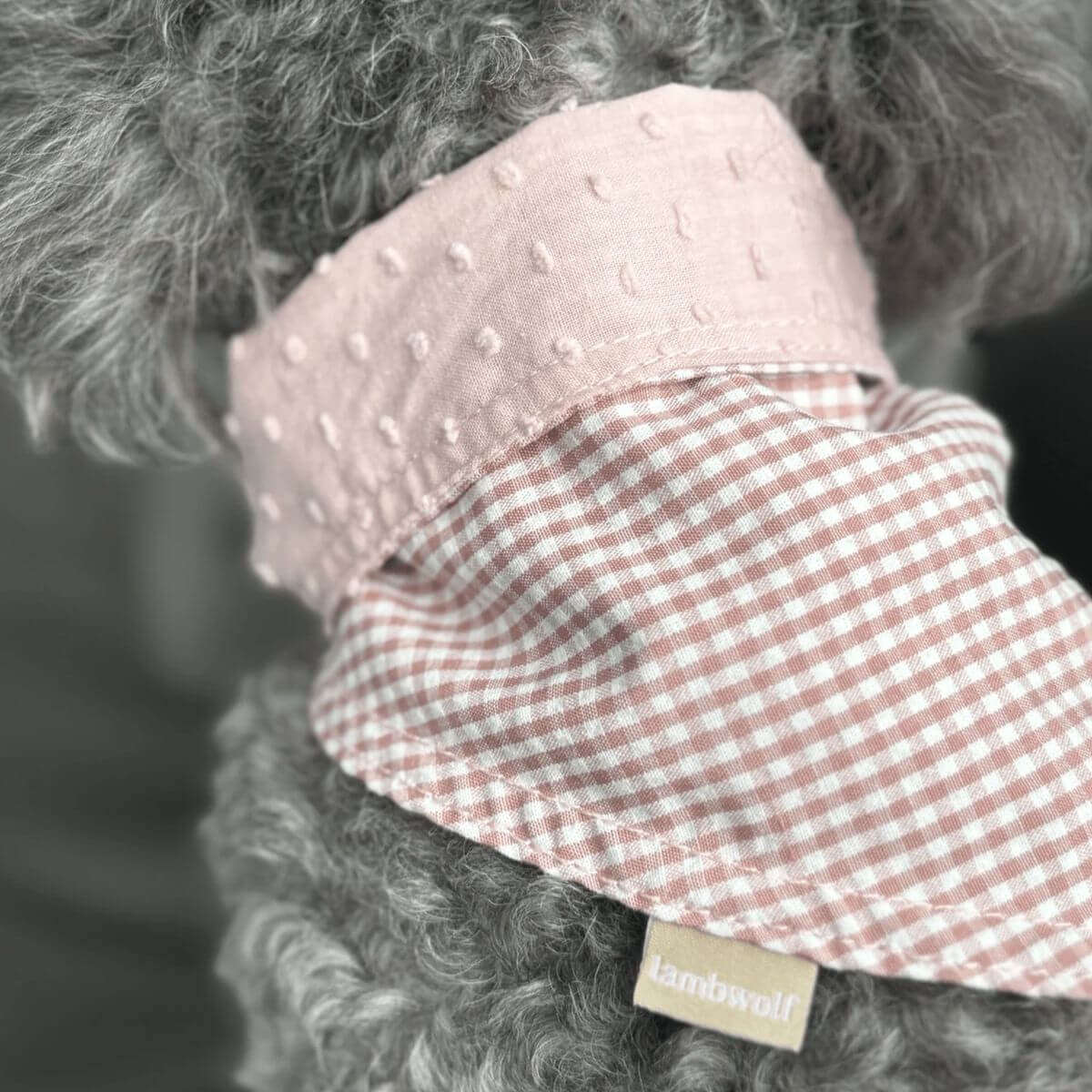 lambwolf reversible pink bandana on a grey poodle.