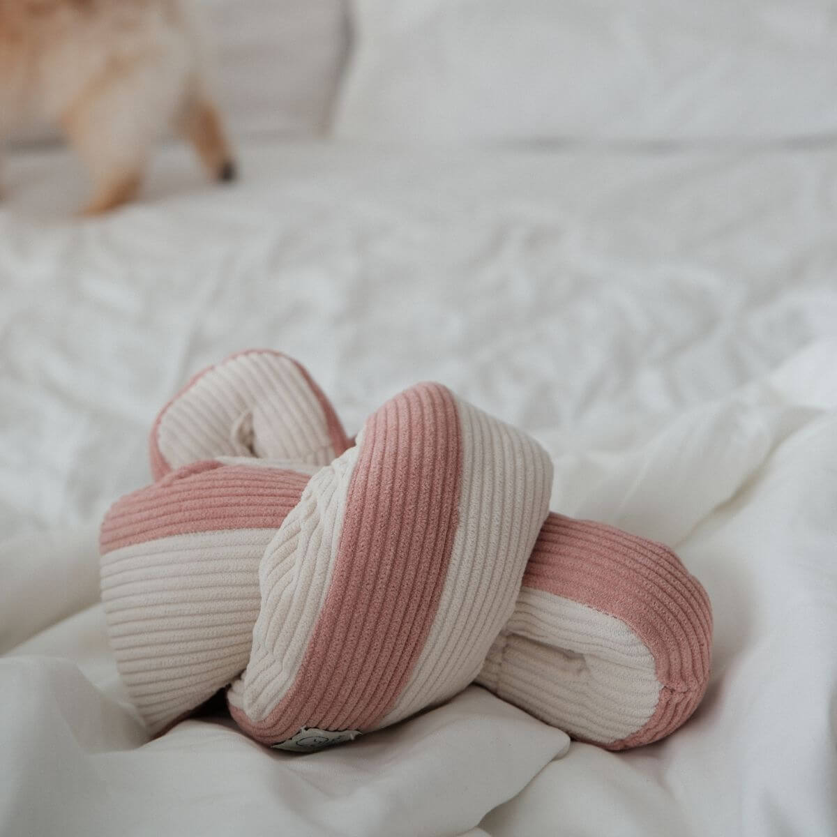 Lunoji Udon Snuffle Blush Pink against a white sheet on a bed or sofa.