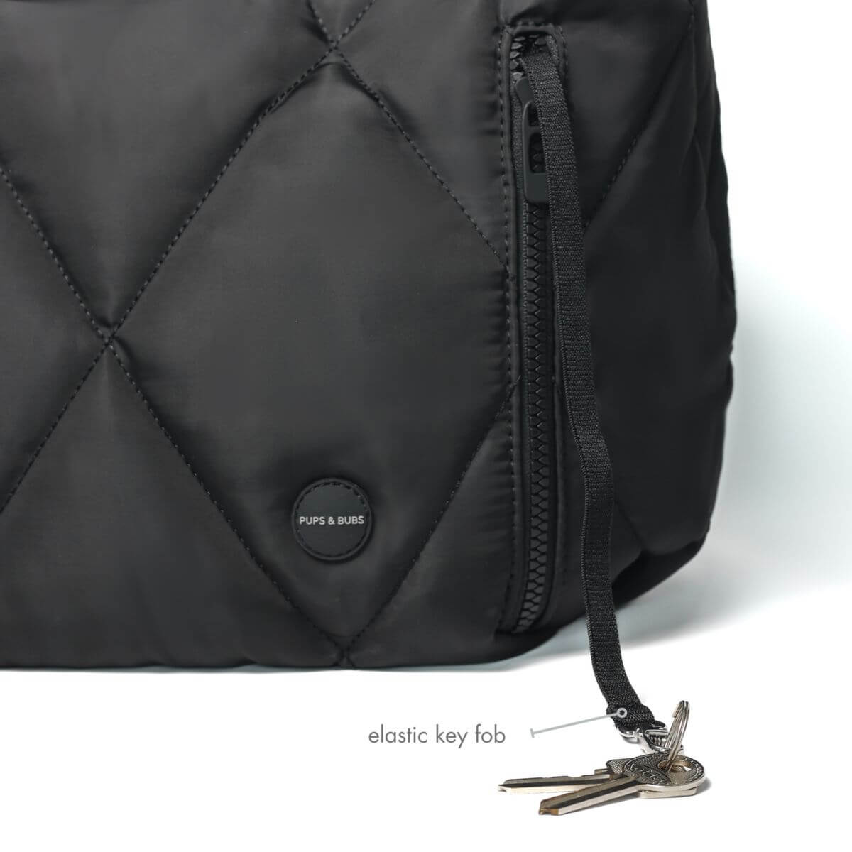 Pups & Bubs Cloud Crossbody Carrier in Black with a key fob against a white background.