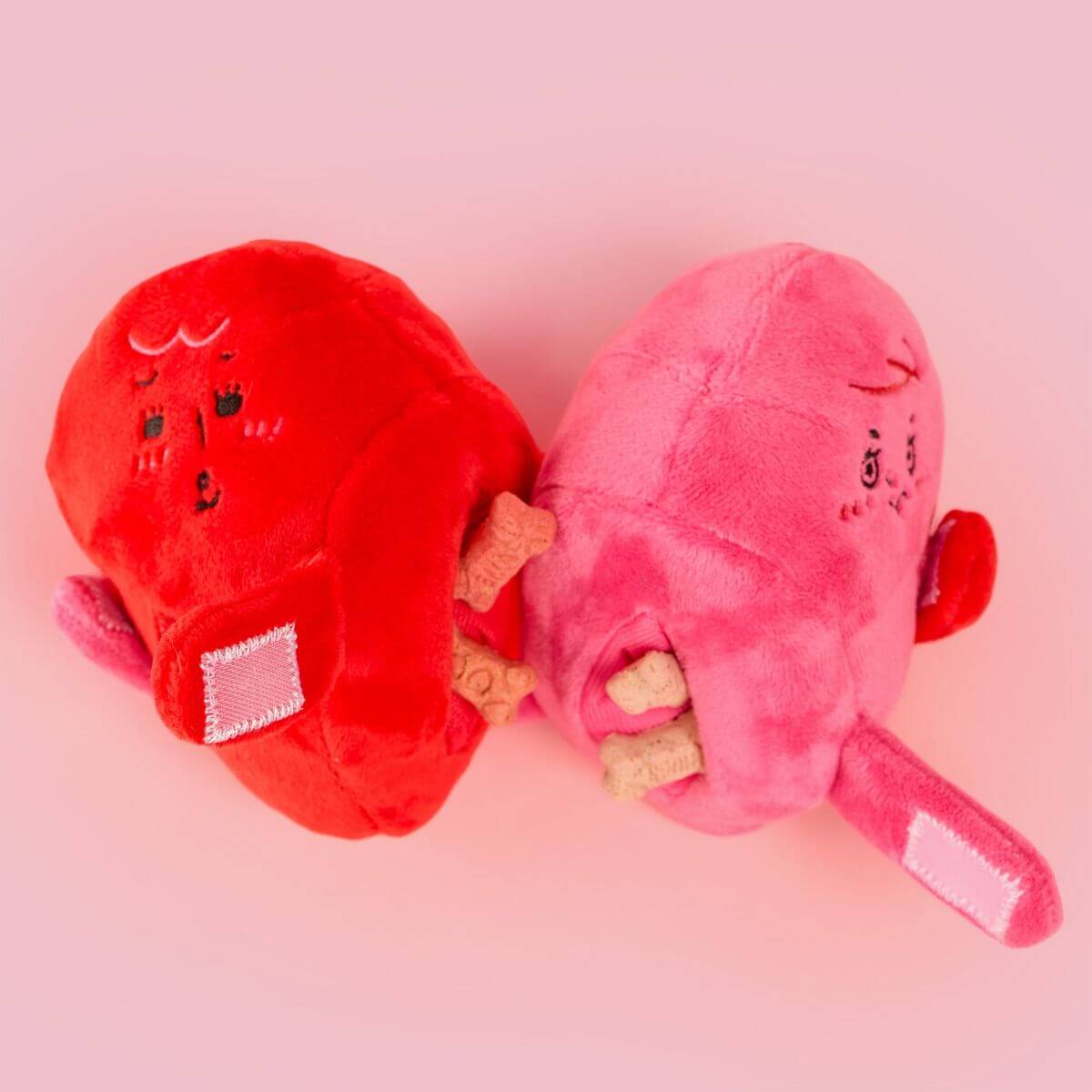 the furryfolks love locked nosework toy with treats in the pockets against a pink background.