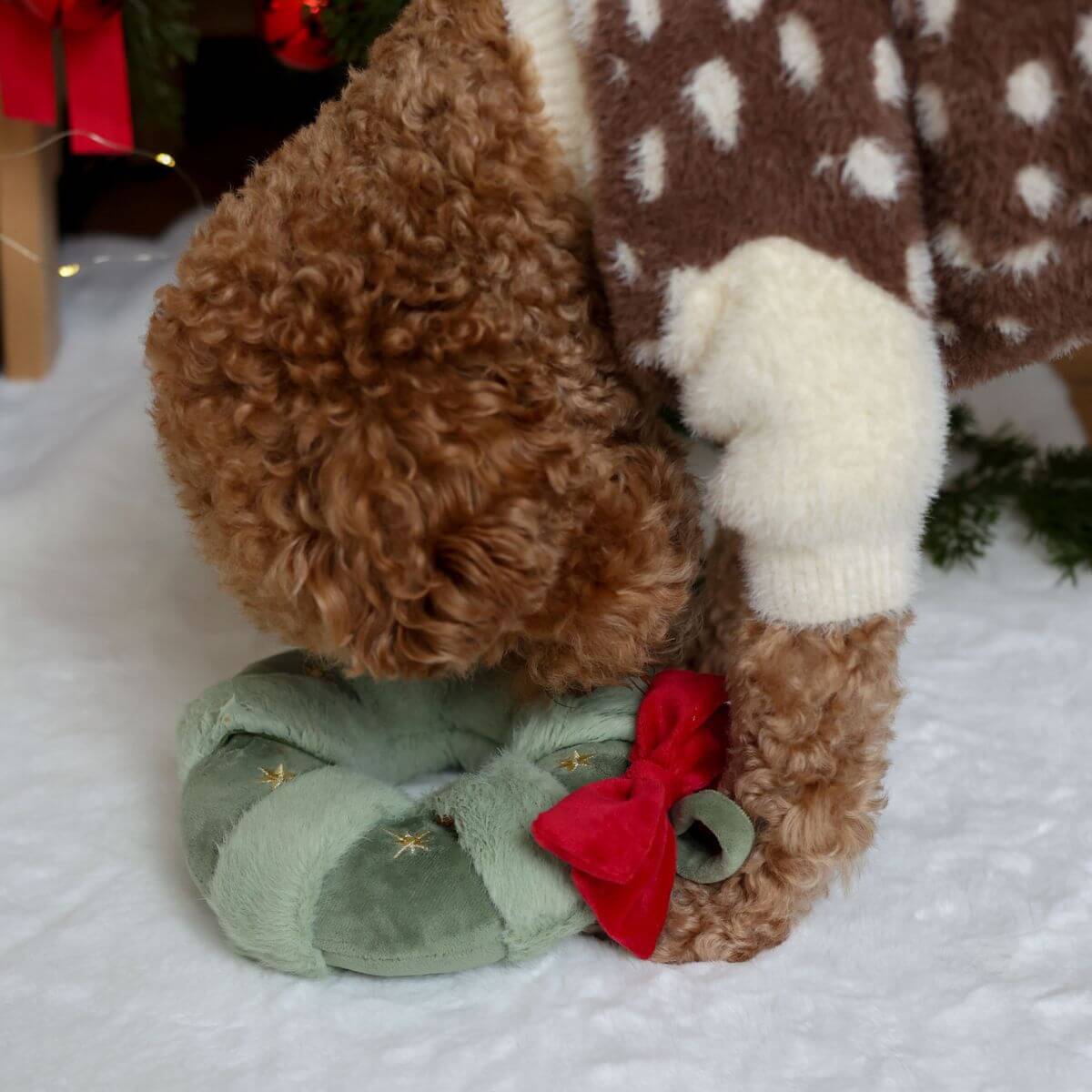 A poodle playing with the Pups & Bubs Festive Wreath Nosework Toy.