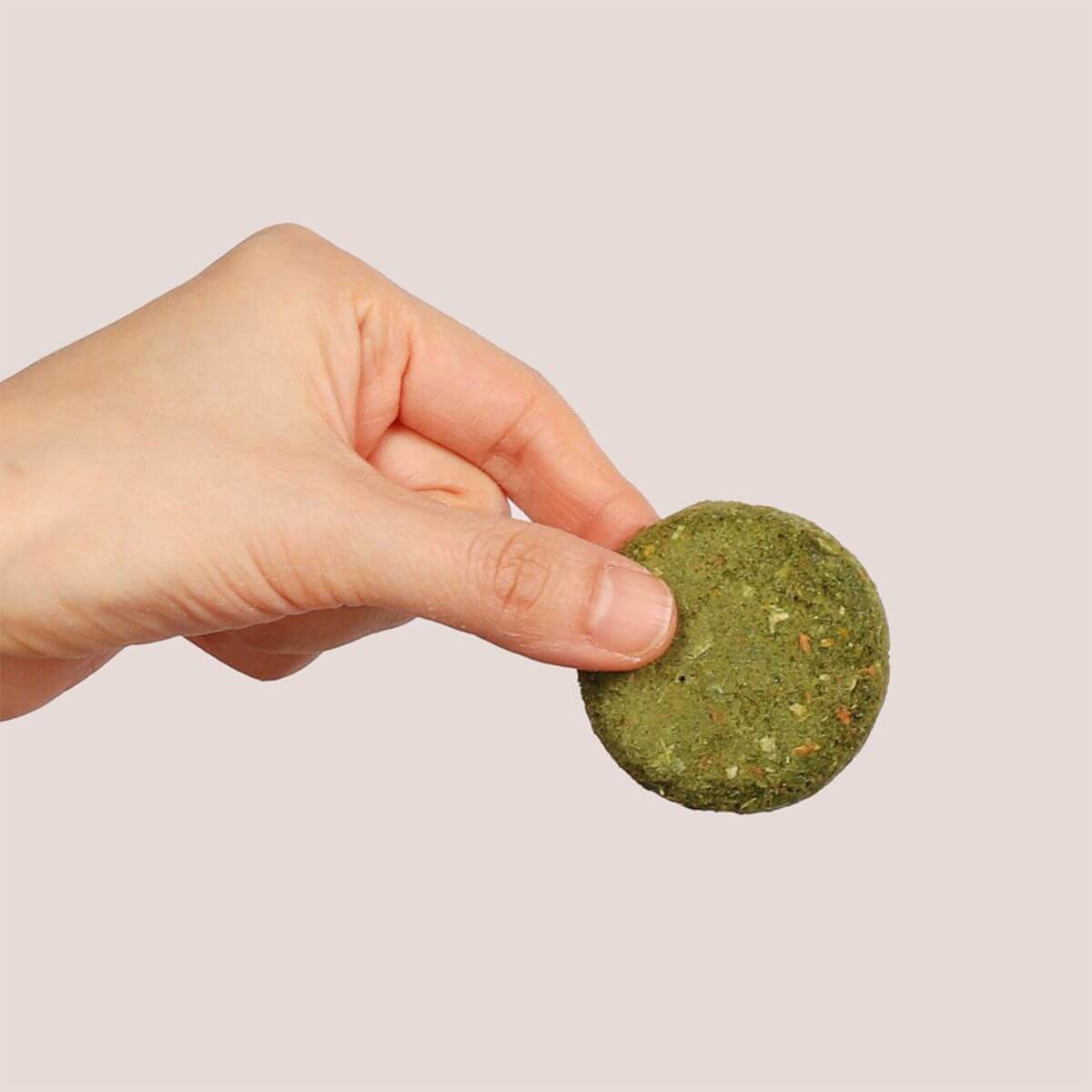A hand holding up a piece of the Arlo Kitchen Detox Veggie Patties.
