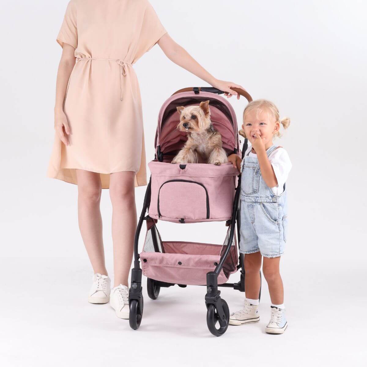 Bernd Pets Autofold Lina in Baby Pink against a white background with a dog in the stroller and a kid beside it.