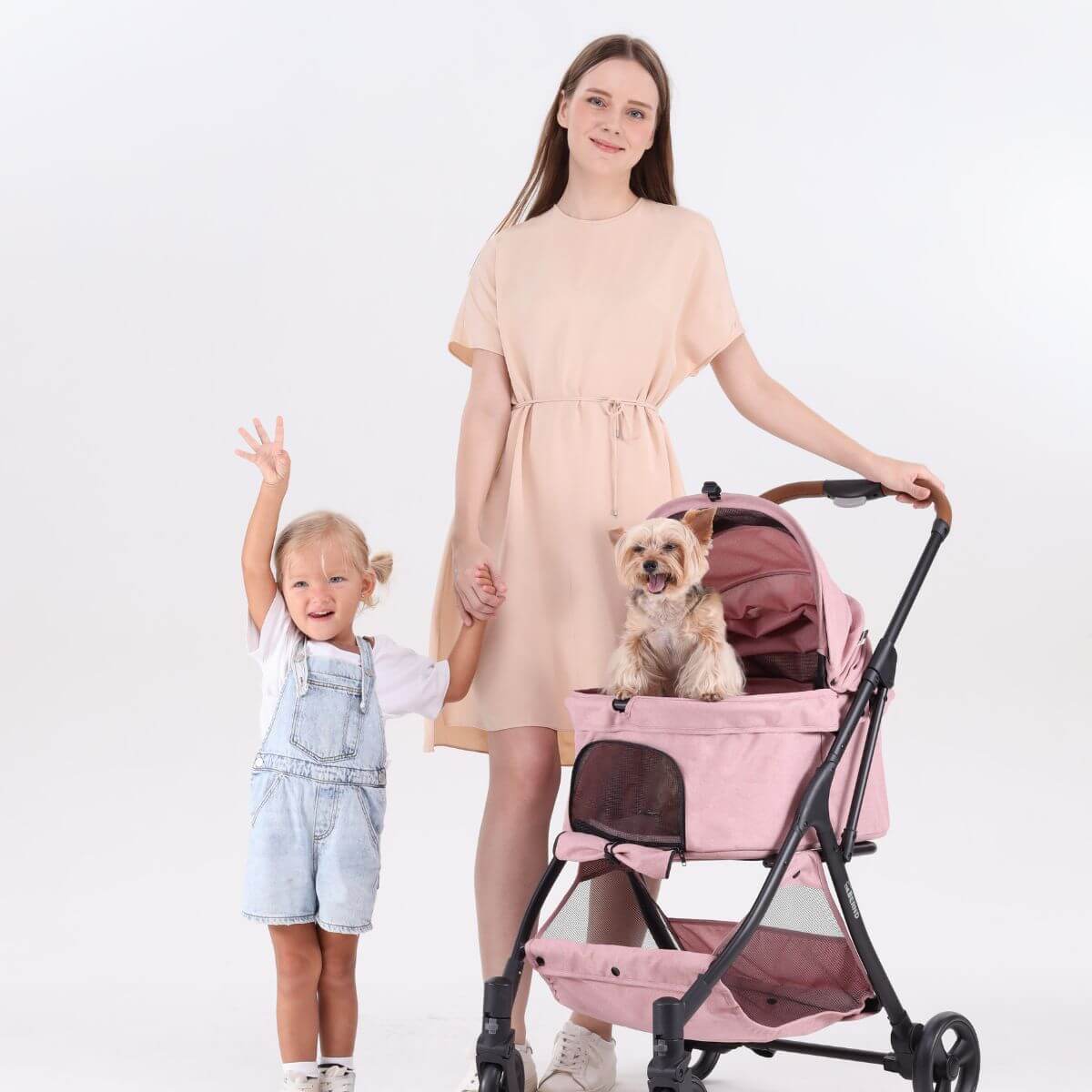 A woman and a kid pushing the Bernd Pets Autofold Lina in Baby Pink against a white background.