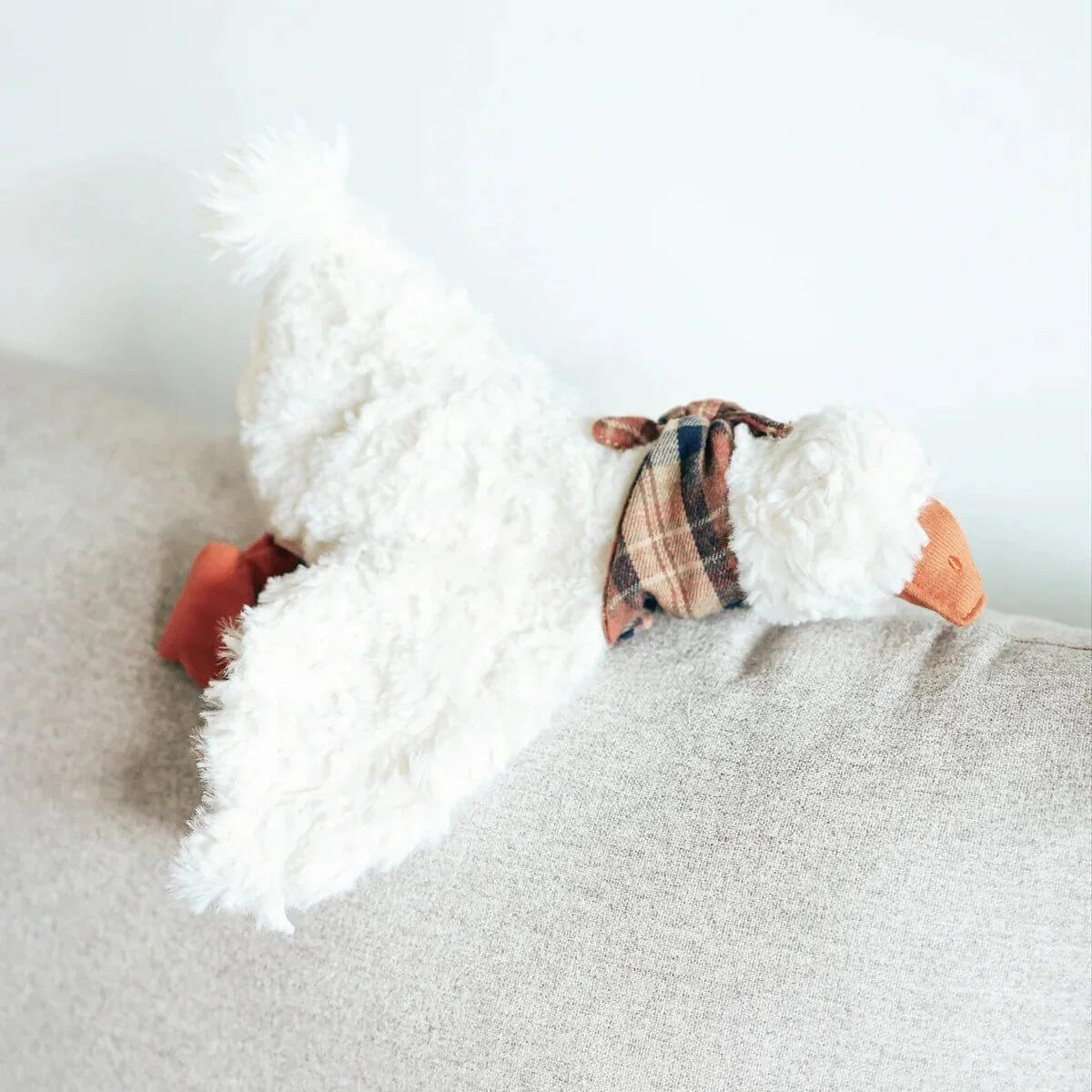 Lambwolf Gus Goose lying on a sofa. 