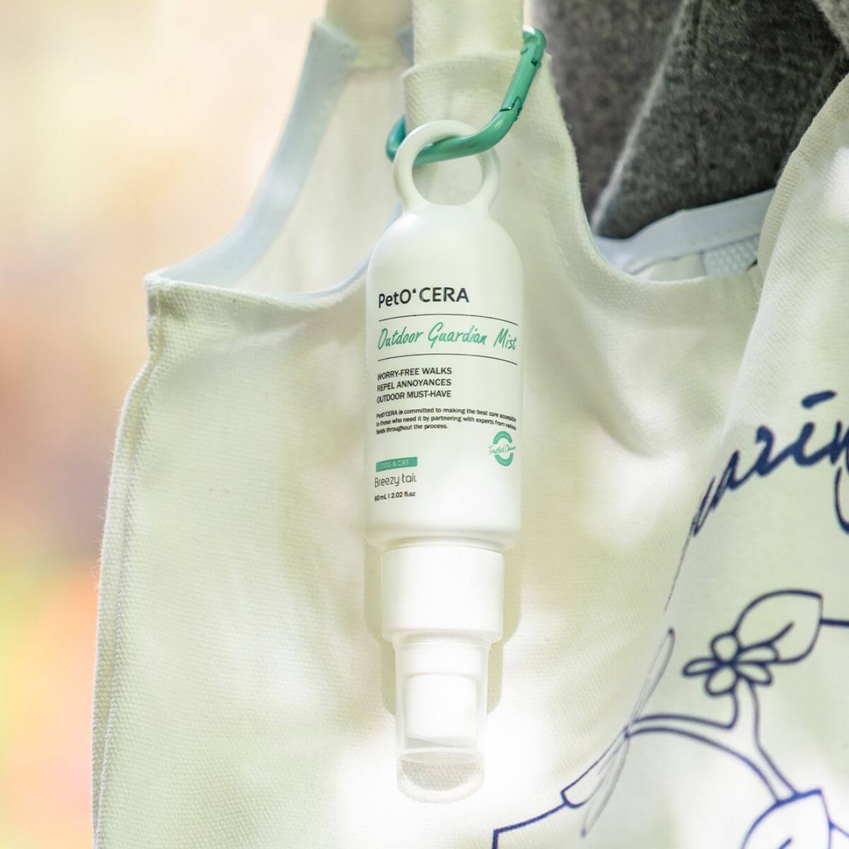 The PetO'CERA Outdoor Guardian Mist outdoors and attached onto a bag strap.