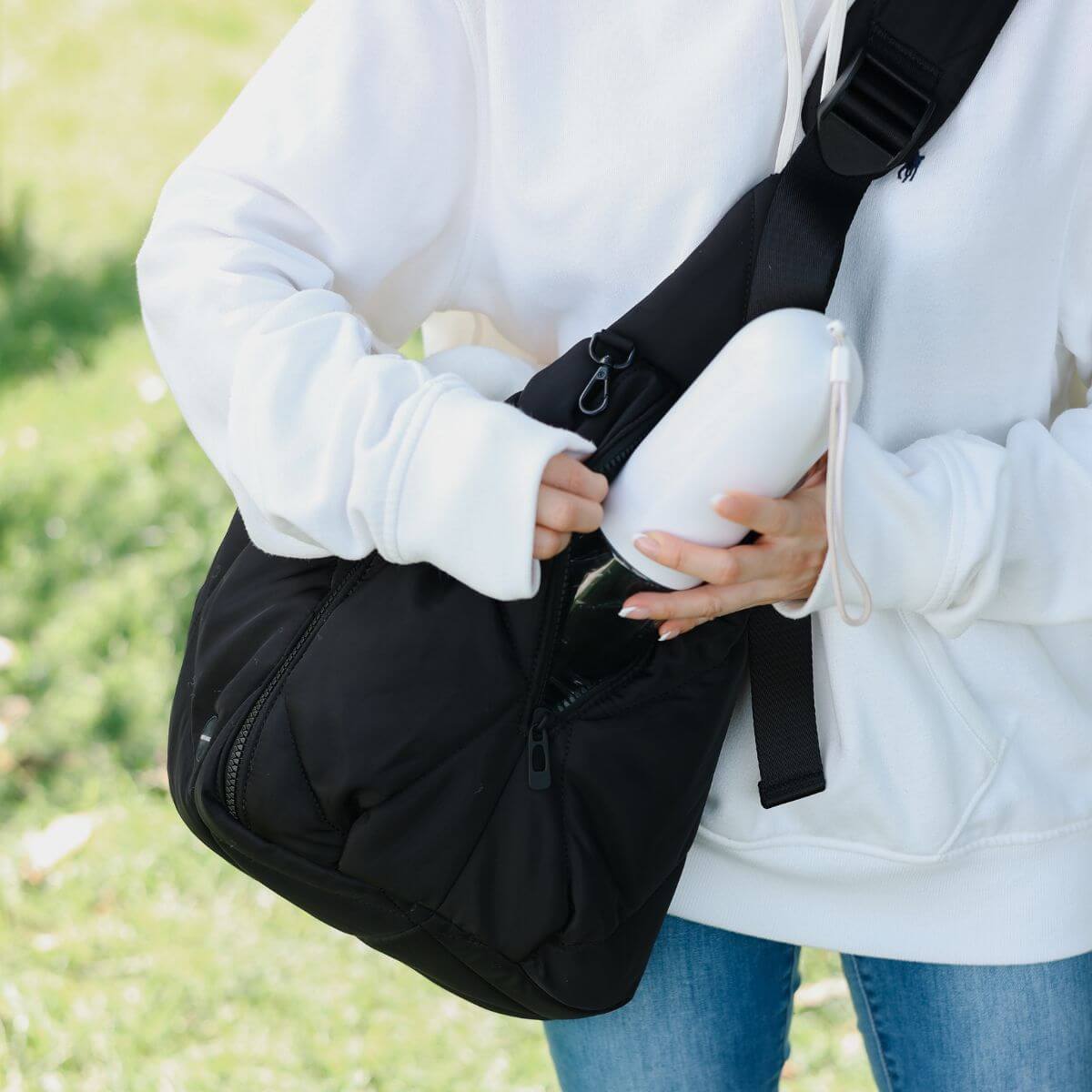 Pups & Bubs Cloud Crossbody Carrier in Black with a bottle pocket.