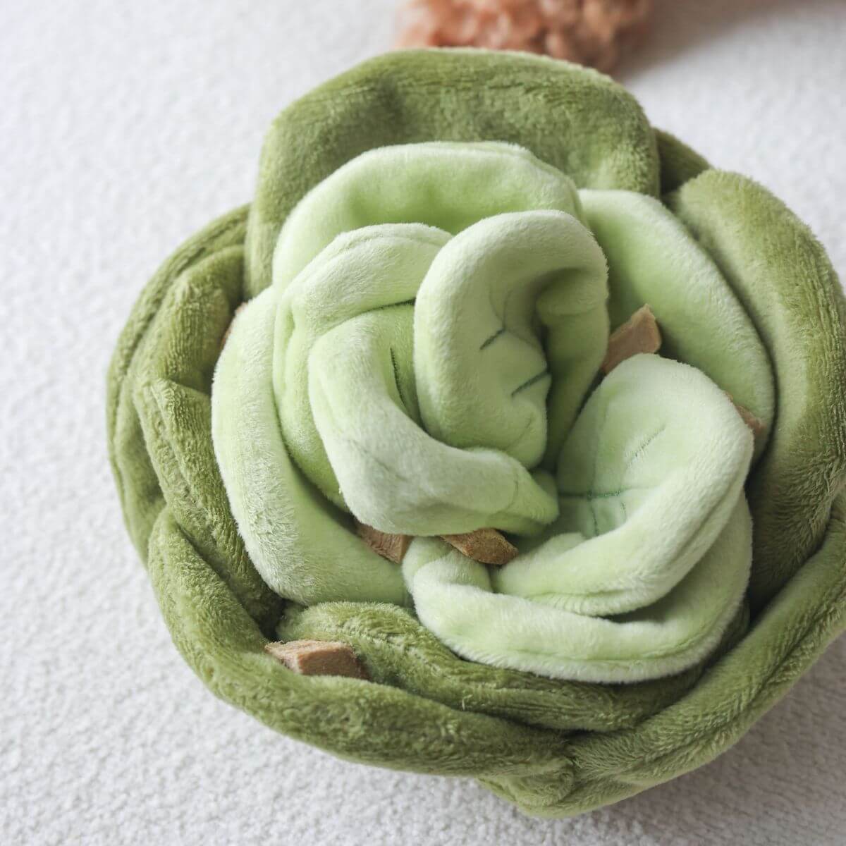 Pups & Bubs Snuffle Cabbage Nosework Toy against a carpet.