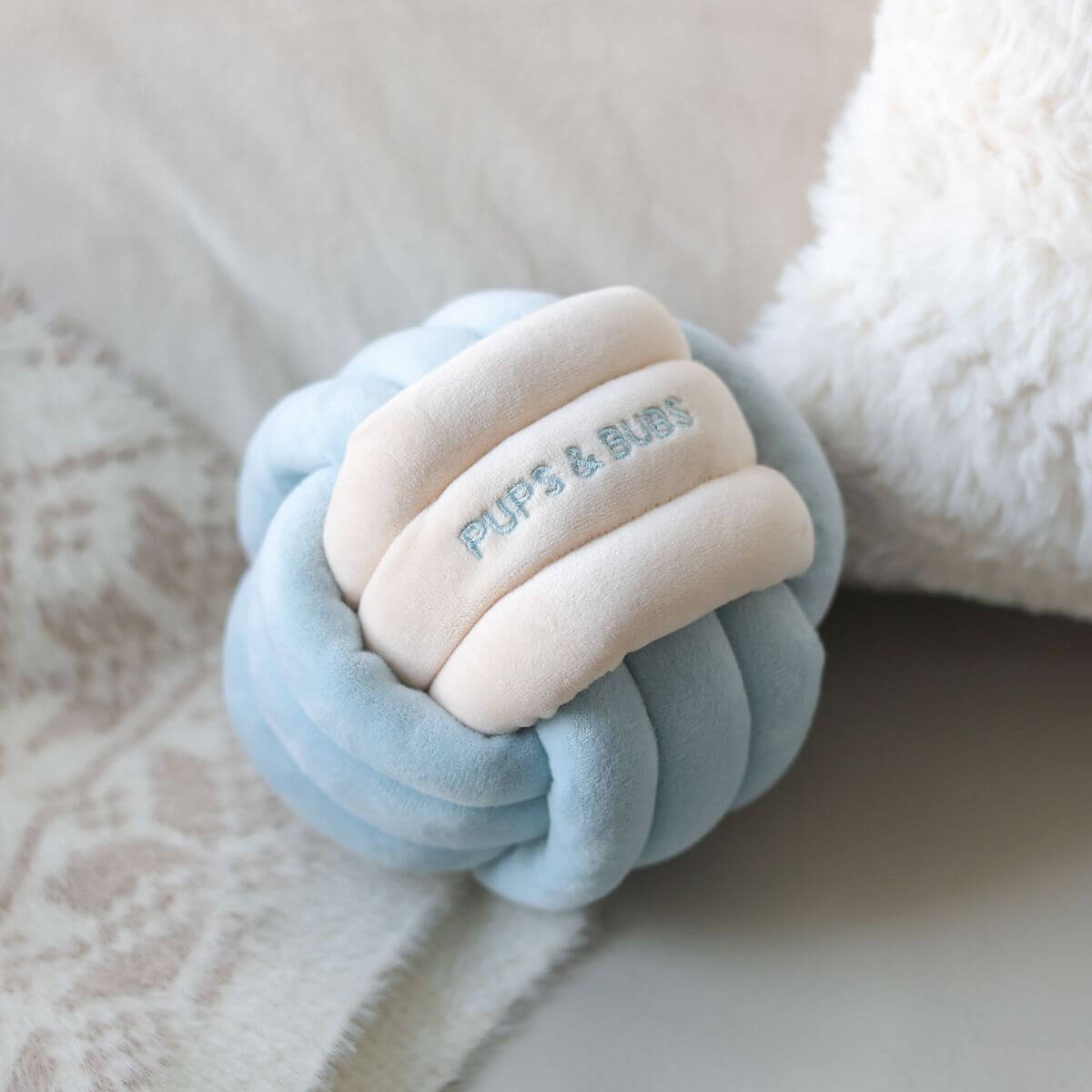 Pups & Bubs Snuffle Knot on a sofa.