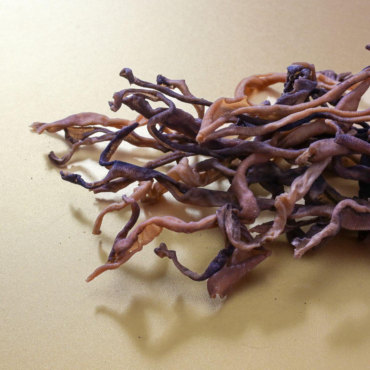 taki pets naaf wagyu stomach tripe against a gold background.
