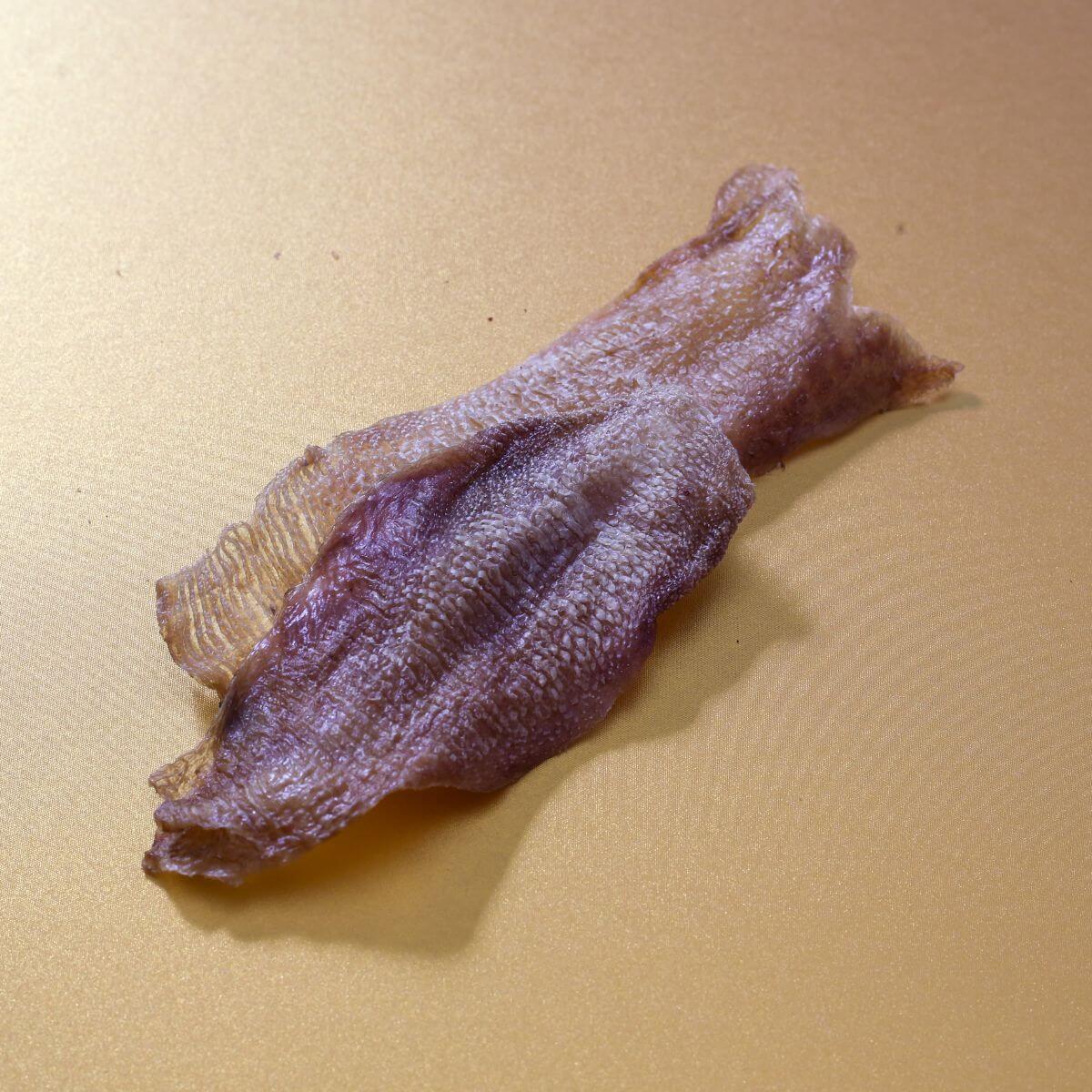 taki pets naaf wagyu tongue skin against a yellow background.