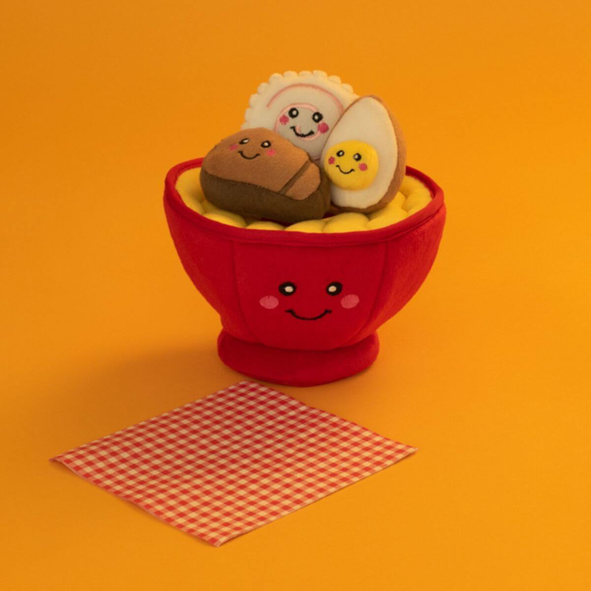 ZippyPaws Ramen Bowl against an orange background with a checkered serviette. 
